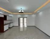 کابینت های سفید قهوه ای و سقف نورپردازی شده با نور زرد آشپزخانه ویلا در جویبار