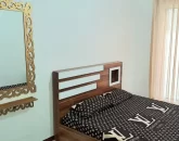 تخت خواب با روتختی قهوه ای و آیینه اتاق خواب ویلا در جویبار