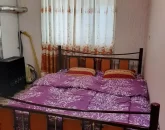 تخت خواب با روتختی صورتی و بخاری اتاق خواب ویلا در ساری