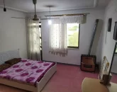 تخت خواب با روتختی صورتی و بخاری و میز آرایش اتاق خواب ویلا در نکا