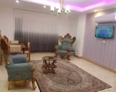 مبلمان سلطنتی ومیزغذاخوری و سقف نور پردازی شده با نور بنفش و سفید سالن نشیمن آپارتمان در قائم شهر