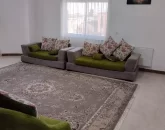 مبلمان طوسی سبز و فرش کرمی سالن نشیمن آپارتمان در نکا