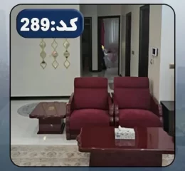 مبلمان زرشکی و فرش کرمی رنگ و سقف نورپردازی شده با نور سفید سالن نشیمن آپارتمان در خورشید کلا