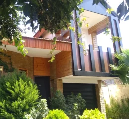 نمای بیرونی ساختمان دو طبقه در کنار محوطه سازی سرسبز ویلا در ساری 37463787567