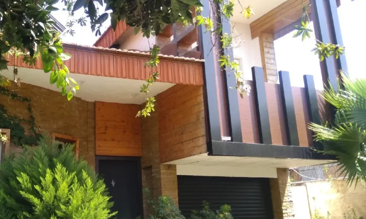 نمای بیرونی ساختمان دو طبقه در کنار محوطه سازی سرسبز ویلا در ساری 37463787567