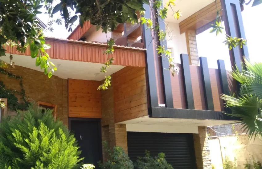 نمای بیرونی ساختمان دو طبقه در کنار محوطه سازی سرسبز ویلا در ساری 37463787567