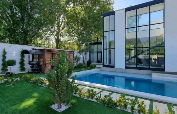 نمای بیرونی شیشه ای و جکوزی و استخر در حیاط ویلای 546 متری در نصیرآباد 05165874168676