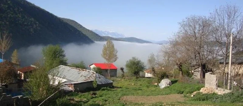 ارتفاعات بالای کوه های روستای اسکارد و دیده شدن مه در کنار کلبه های چوبی 416874676