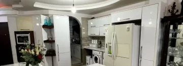 یخچال و لباسشویی و کابینت های سفید آشپزخانه آپارتمان در زاغمرز