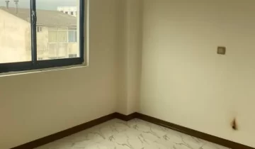 سرامیک سفید و پنجره رو به آپارتمان های اطراف اتاق خواب آپارتمان در نکا