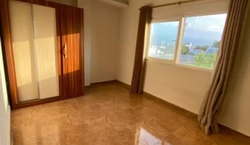 سرامیک قهوه ای و کمددیواری و پنجره رو به محوطه سرسبز اتاق خواب آپارتمان در ساری