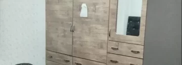 کمددیواری وتخت خواب با روتختی صورتی و کاغذ دیواری سفید اتاق خواب آپارتمان در نکا