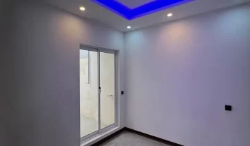 پنجره رو به محوطه و سقف نور پردازی شده با نور آبی اتاق خواب ویلا در زاغمرز