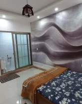 تخت خواب با روتختی سورمه ای و کاغذ دیواری و سرویس بهداشتی اتاق خواب ویلا در ساری