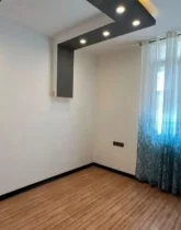 اتاق خواب نورپردازی شده با نور زرد و پرده ی طرح دار آبی ویلا در نکا