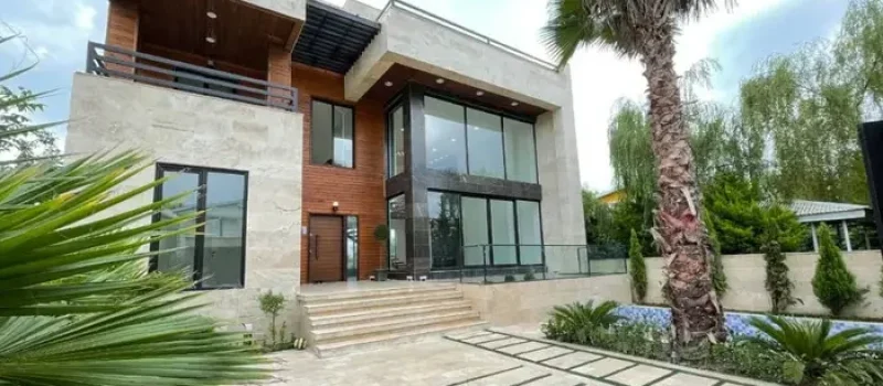 ویلا با نمای سفید قهوه ای و محوطه سنگ فرش شده و باغچه سرسبز 215212