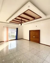 سرامیک سفید و نورپردازی سقف با نور سفید سالن نشیمن با پنجره ای رو به خیابان خانه روستایی در طاهر آباد