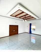 سرامیک سفید و پرده ی ساده آبی رنگ سالن نشیمن خانه روستایی در طاهر آباد