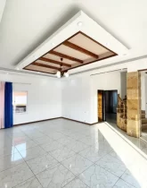 سرامیک سفید سالن نشیمن وپله های قهوه ای رنگ و درهای چوبی خانه روستایی در طاهر آباد