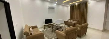 مبلمان قهوه ای و تلویزیون و سقف نورپردازی شده با نور زرد و سفید سالن نشیمن آپارتمان در قائم شهر