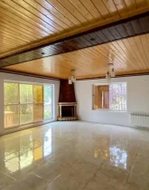 سالن نشیمن با کف سرامیک و شومینه و درب ورودی به حیاط ویلای 310 متری در زاغمرز 4168746874689