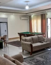 مبلمان کرمی رنگ و میز غذاخوری و فوتبال دستی در سالن نشیمن ویلا در ساری