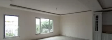 پنجره های رو به محوطه سرسبز و سرامیک کرمی سالن نشیمن ویلا در قائم شهر