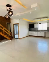 کابینت های سفید و سقف نور پردازی شده با نور زرد آشپزخانه ویلا در جویبار