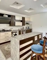 کابینت های سفید قهوه ای و صندلی کانتر و هود آشپزخانه ویلا در طاهرآباد