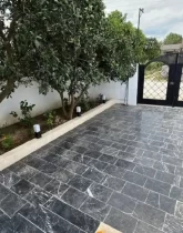 محوطه سنگ فرش شده و باغچه ی سرسبز حیاط ویلا در قائم شهر