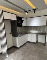 کابینت سفید و هود و سقف نور پردازی شده با نور زرد آشپزخانه ویلا در قائم شهر