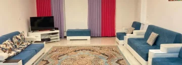 اتاق پذیرایی فرش شده به همراه مبلمان و تلوزیون رو میزی واحد آپارتمان در ساری 48578465476